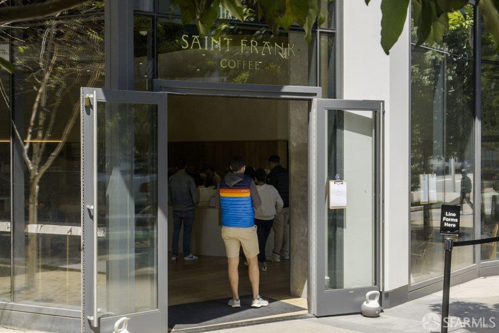 Saint Frank Coffee storefront with open glass doors and a sidewalk line sign.