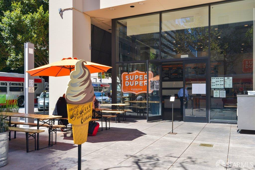 Super Duper Burgers storefront with outdoor seating and a large soft-serve cone sign.