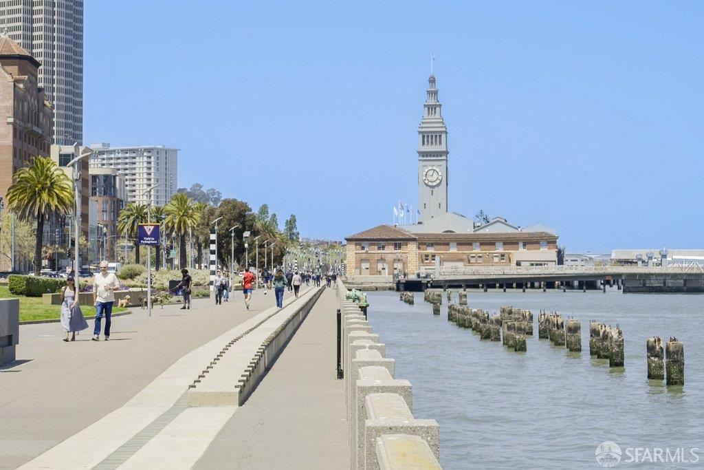 San Francisco waterfront promenade with the Ferry Building clock tower beside the bay.