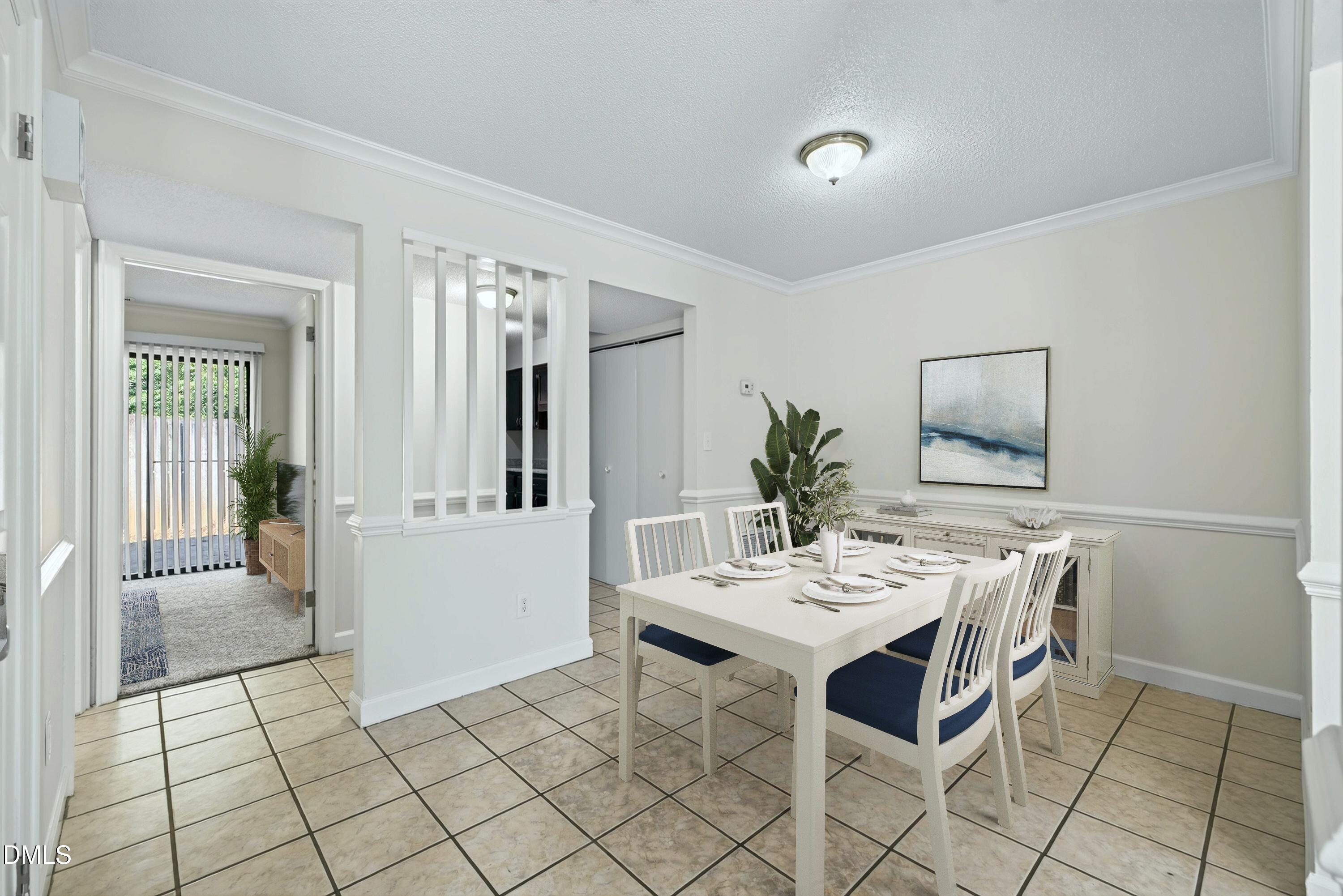 Dining room with a set table, white chairs with navy cushions, and a decorative partition.