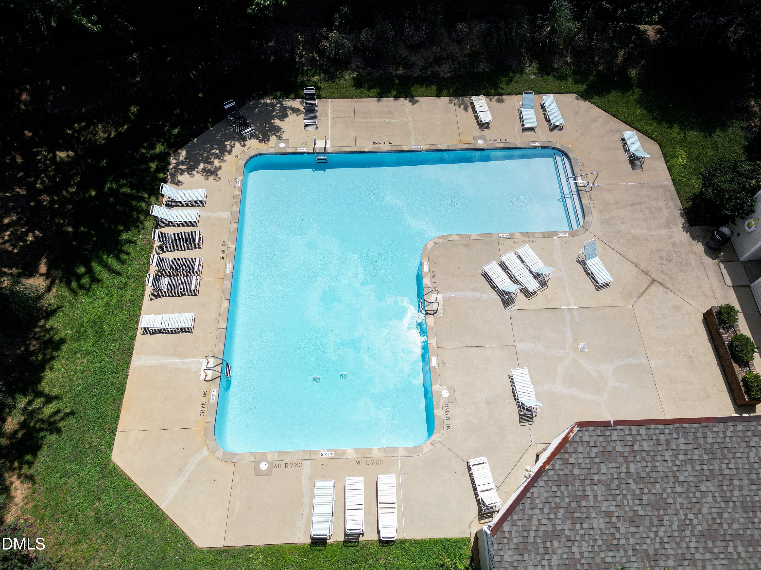 Aerial view of an outdoor pool with lounge chairs on the surrounding deck.
