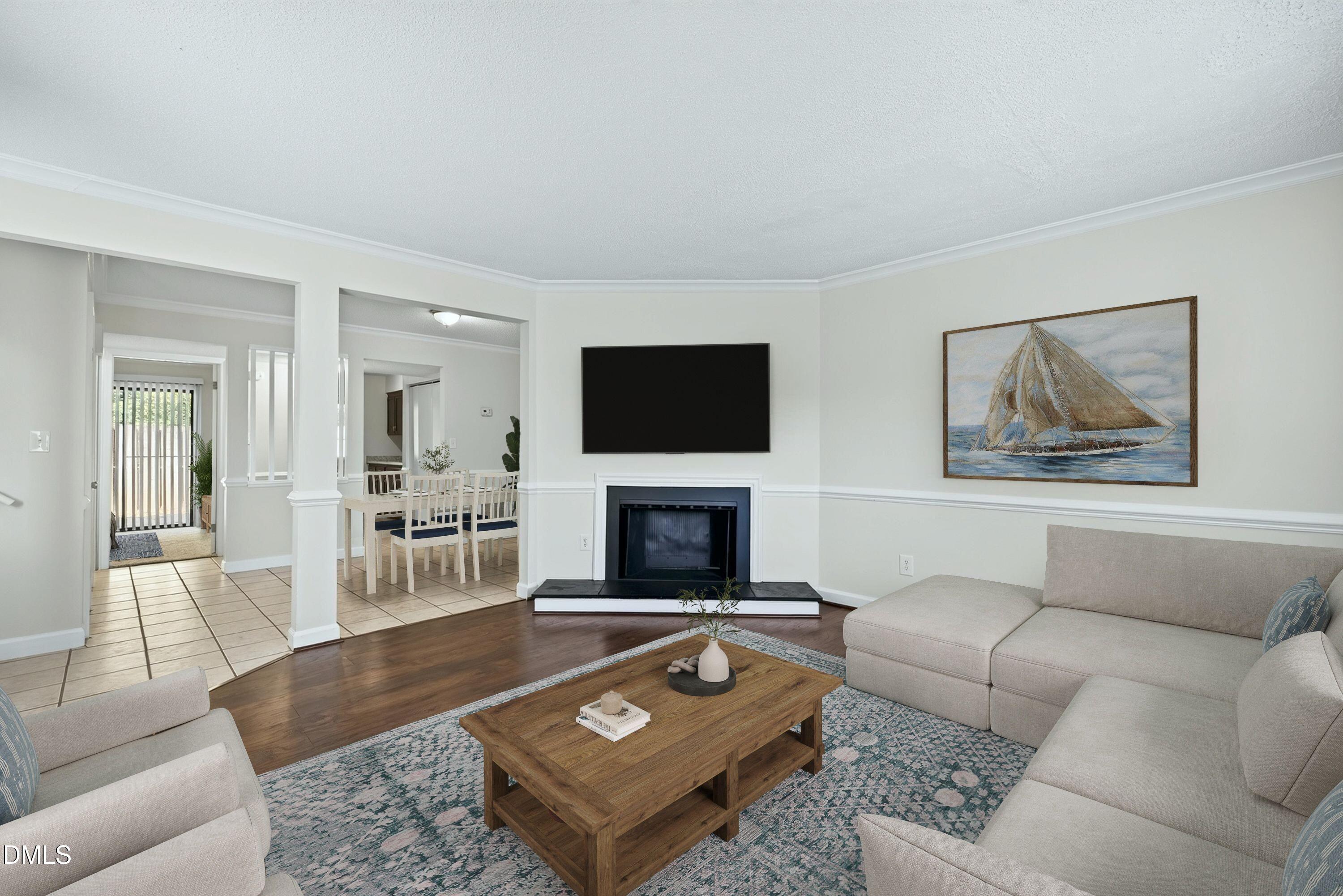 Living room with a fireplace, sectional sofa, and open passage to the dining area.