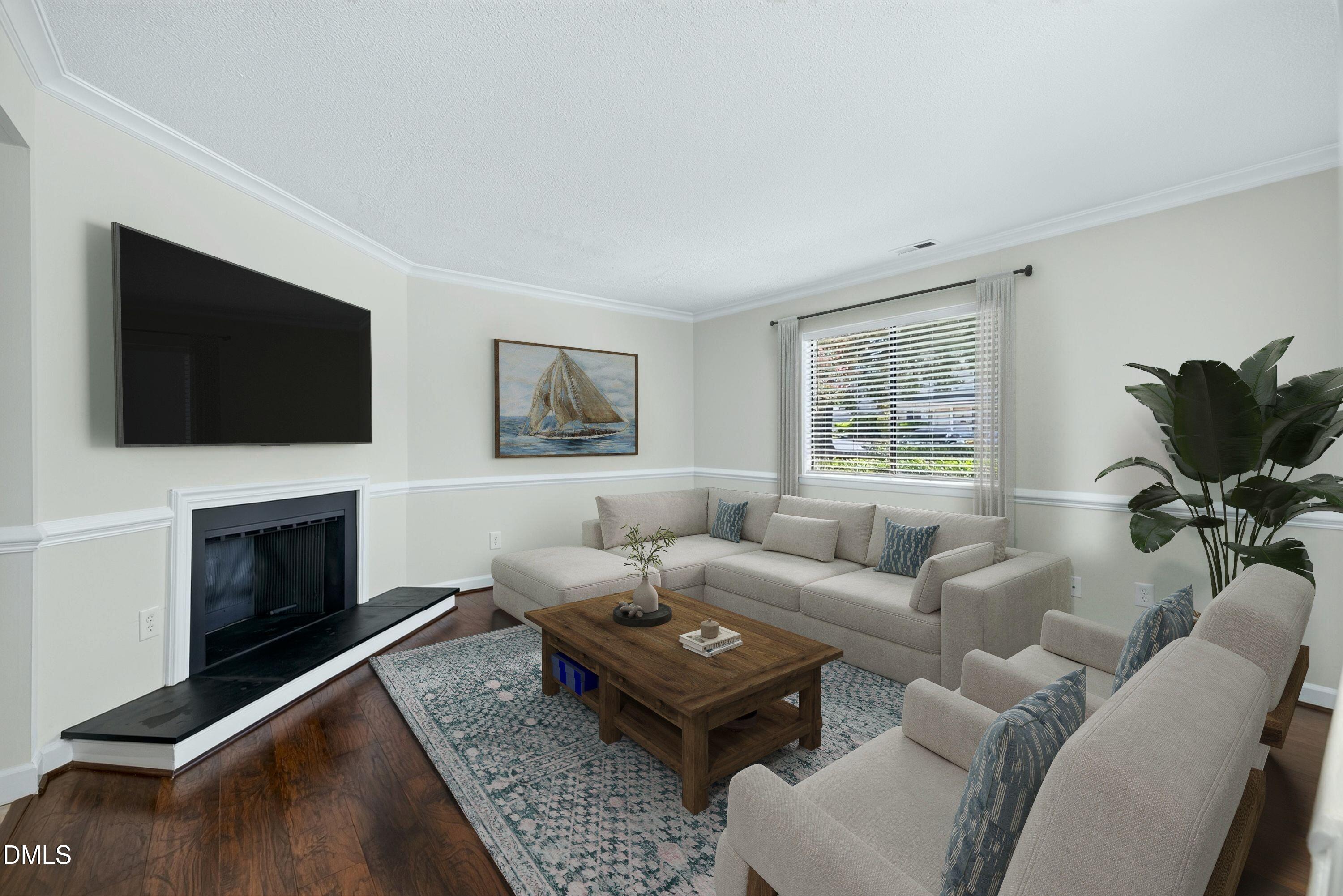 Living room with a light sectional, patterned rug, and fireplace beneath a wall-mounted television.