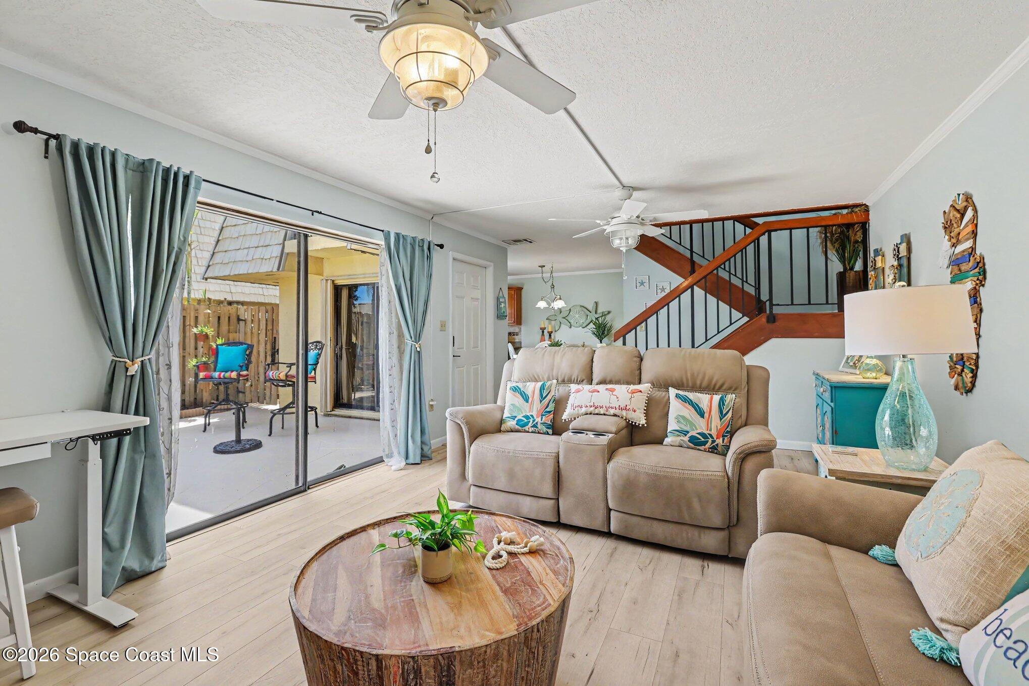 Living room with beige reclining sofas, a wood coffee table, and sliding doors to a fenced patio.