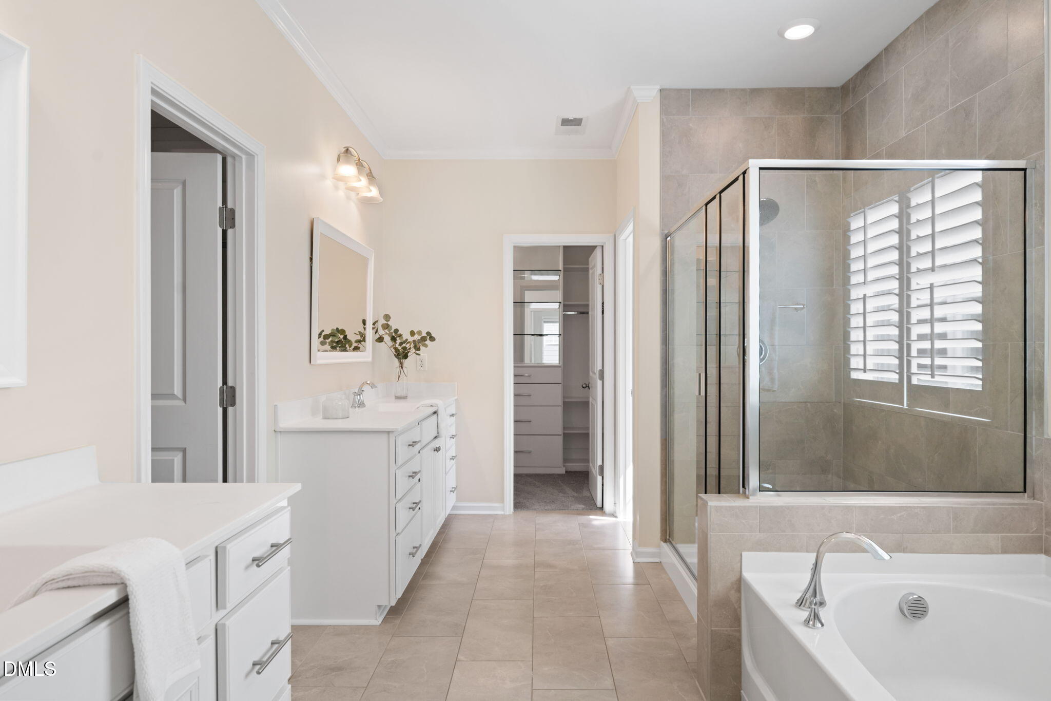 Primary bathroom with double vanities, a tiled glass shower, and a soaking tub.