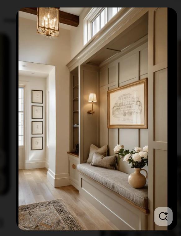 Entry hall with a built-in upholstered bench beneath framed artwork and tall windows.