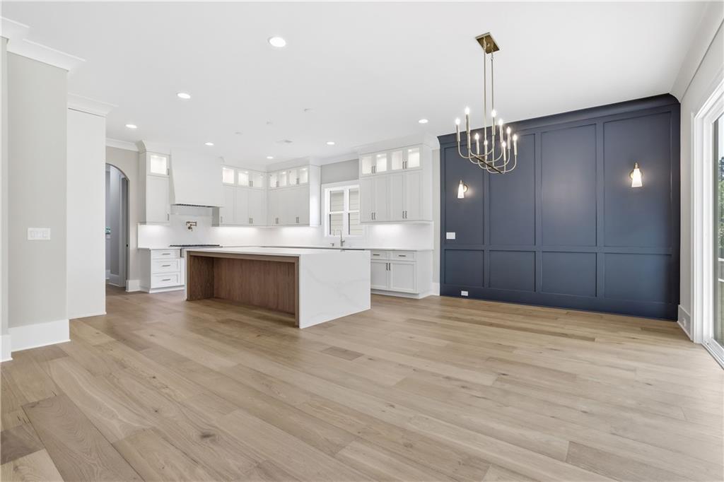 Open-plan kitchen with a large wood-paneled island and navy blue accent wall.