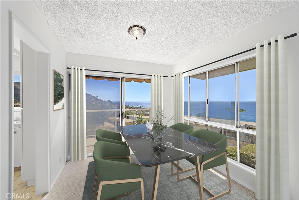 Dining room with green chairs and ocean views through broad corner windows.