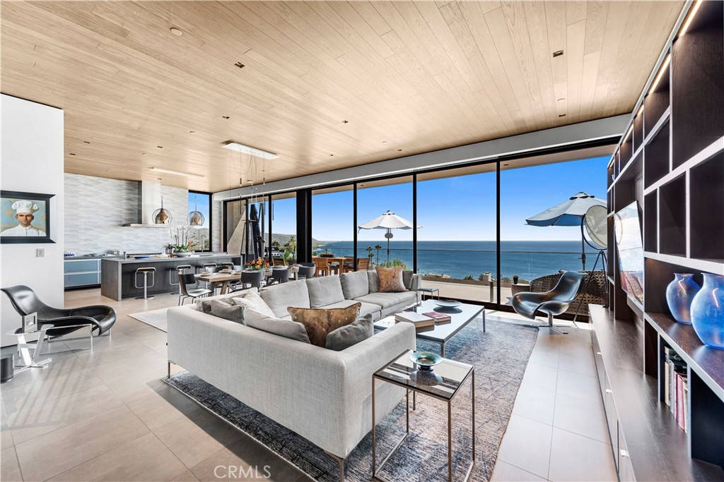 Ocean-view living room with a large sectional sofa and floor-to-ceiling windows.