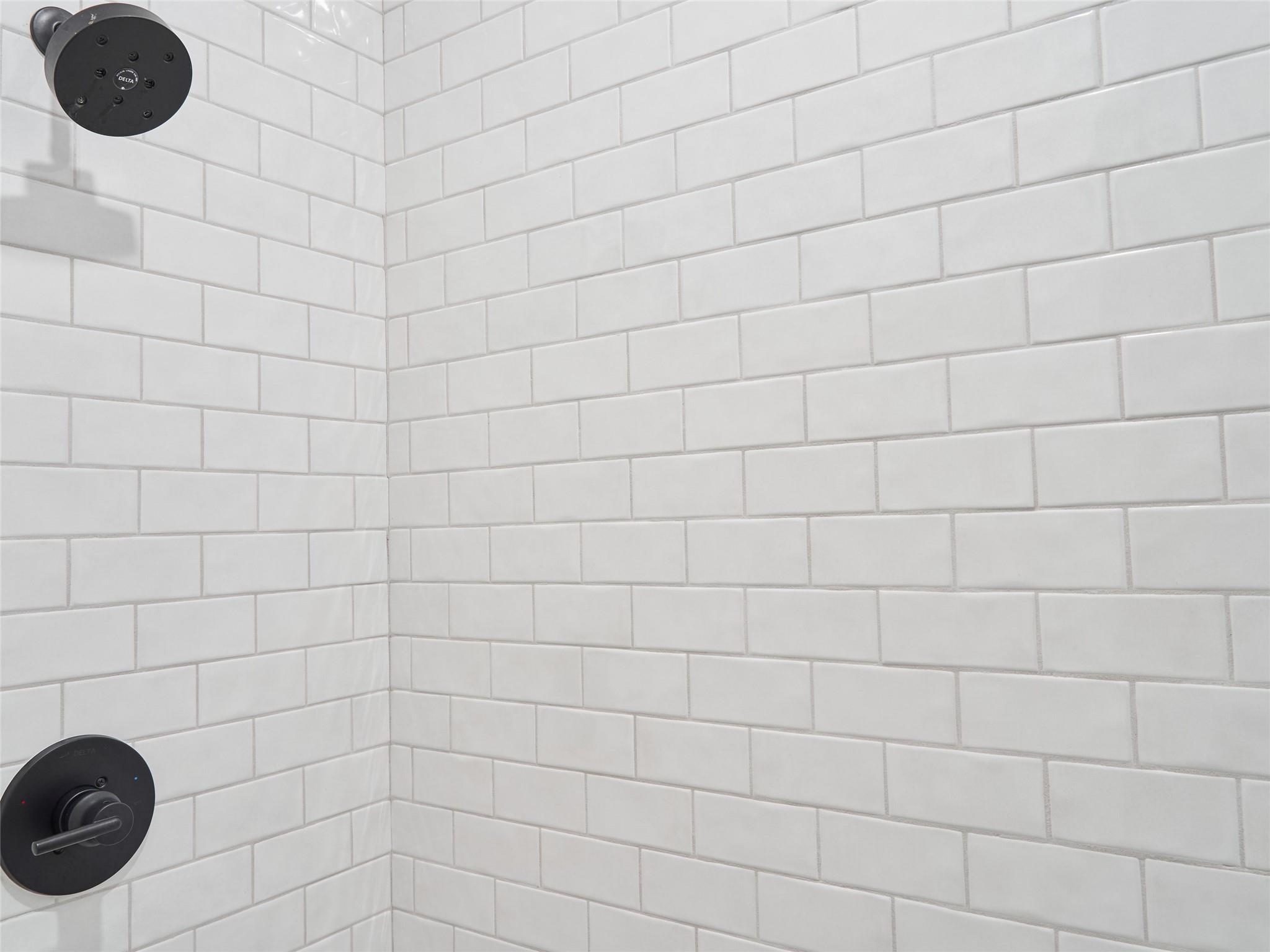 Shower with white subway tile and matte black fixtures.