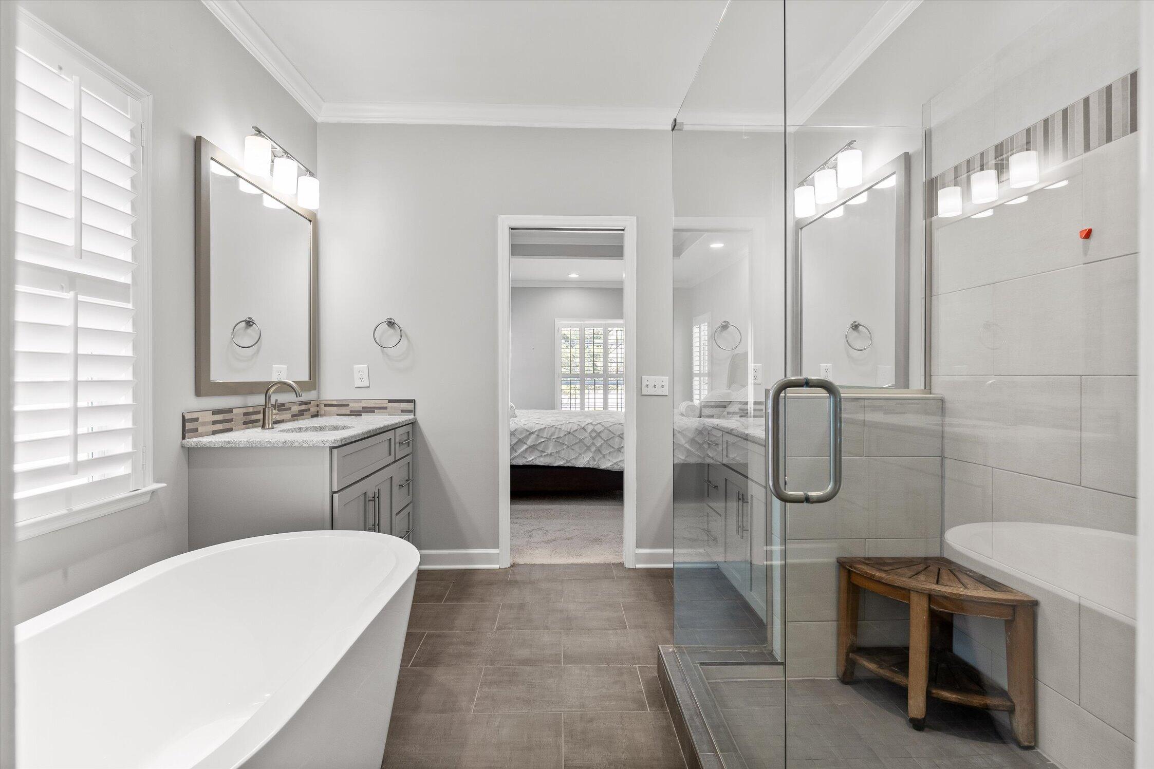 Primary bathroom with a freestanding tub, double vanity, and glass-enclosed shower.