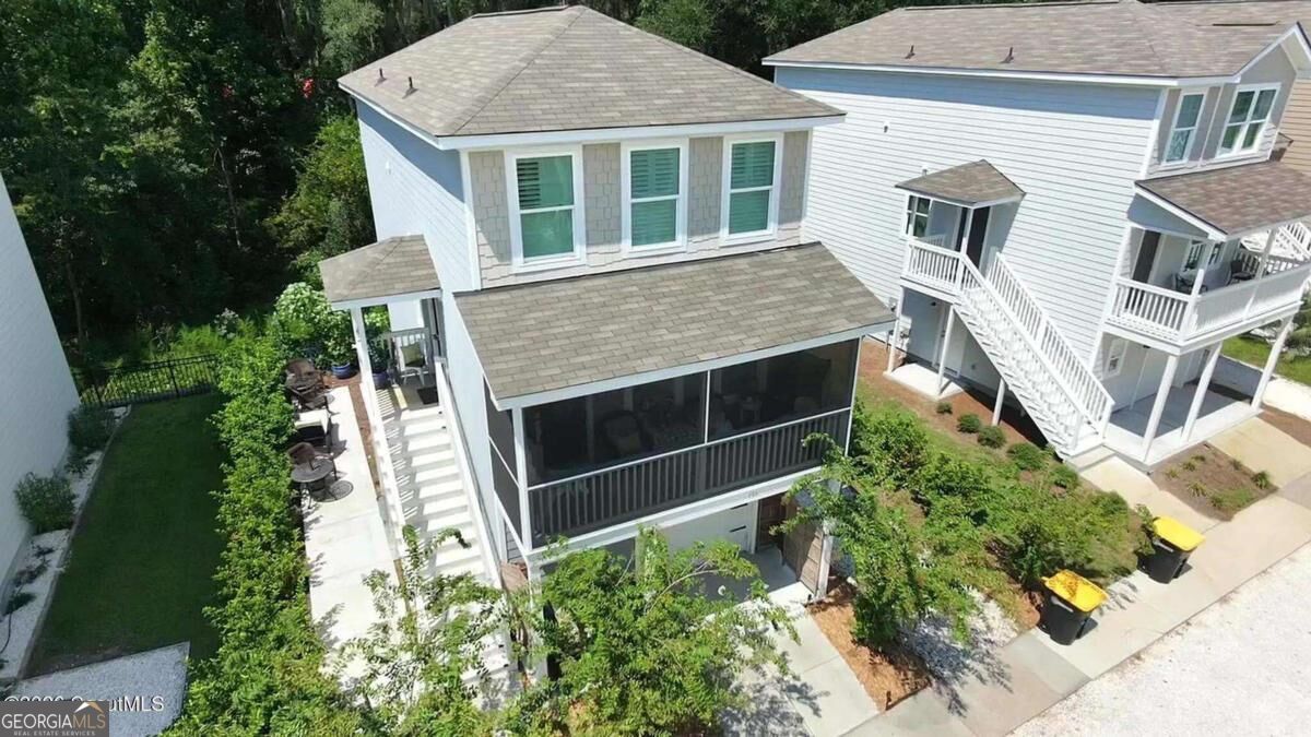 White two-story home with a screened porch and exterior stairs, viewed from above.