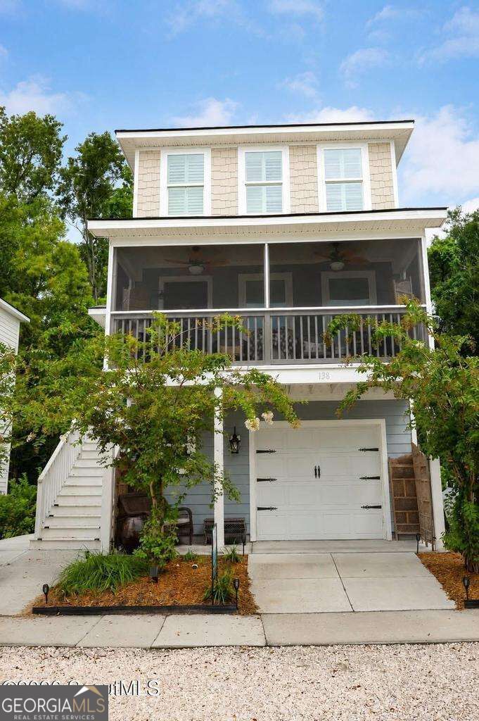 Multi-level home with a screened porch, white garage door, and exterior staircase.