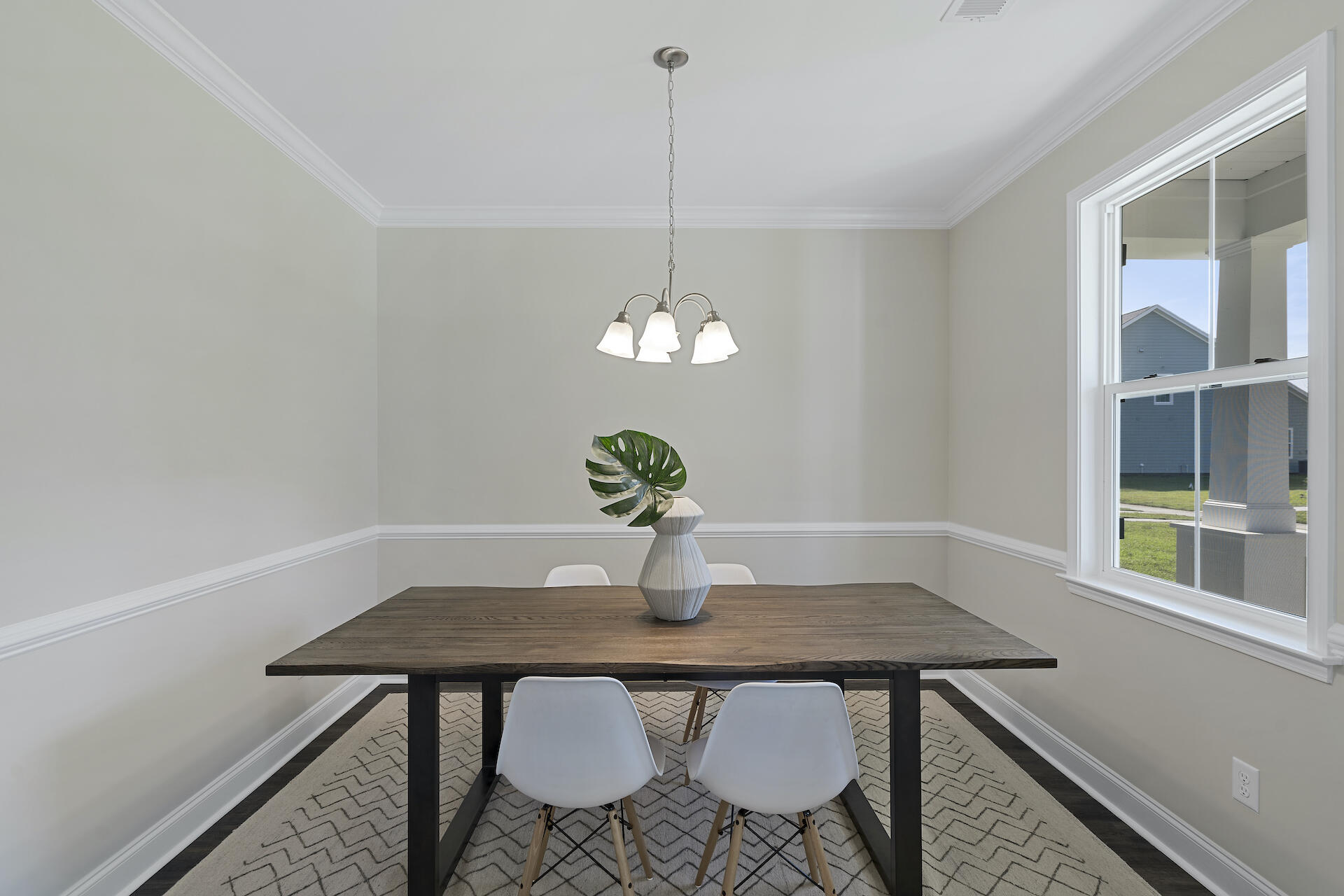 Dining room with a dark wood table, white chairs, and a large window.
