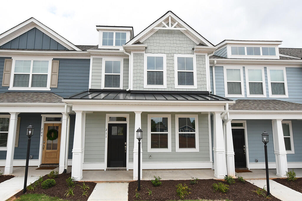 Attached two-story townhomes with blue-gray siding, white trim, and covered entry porches.