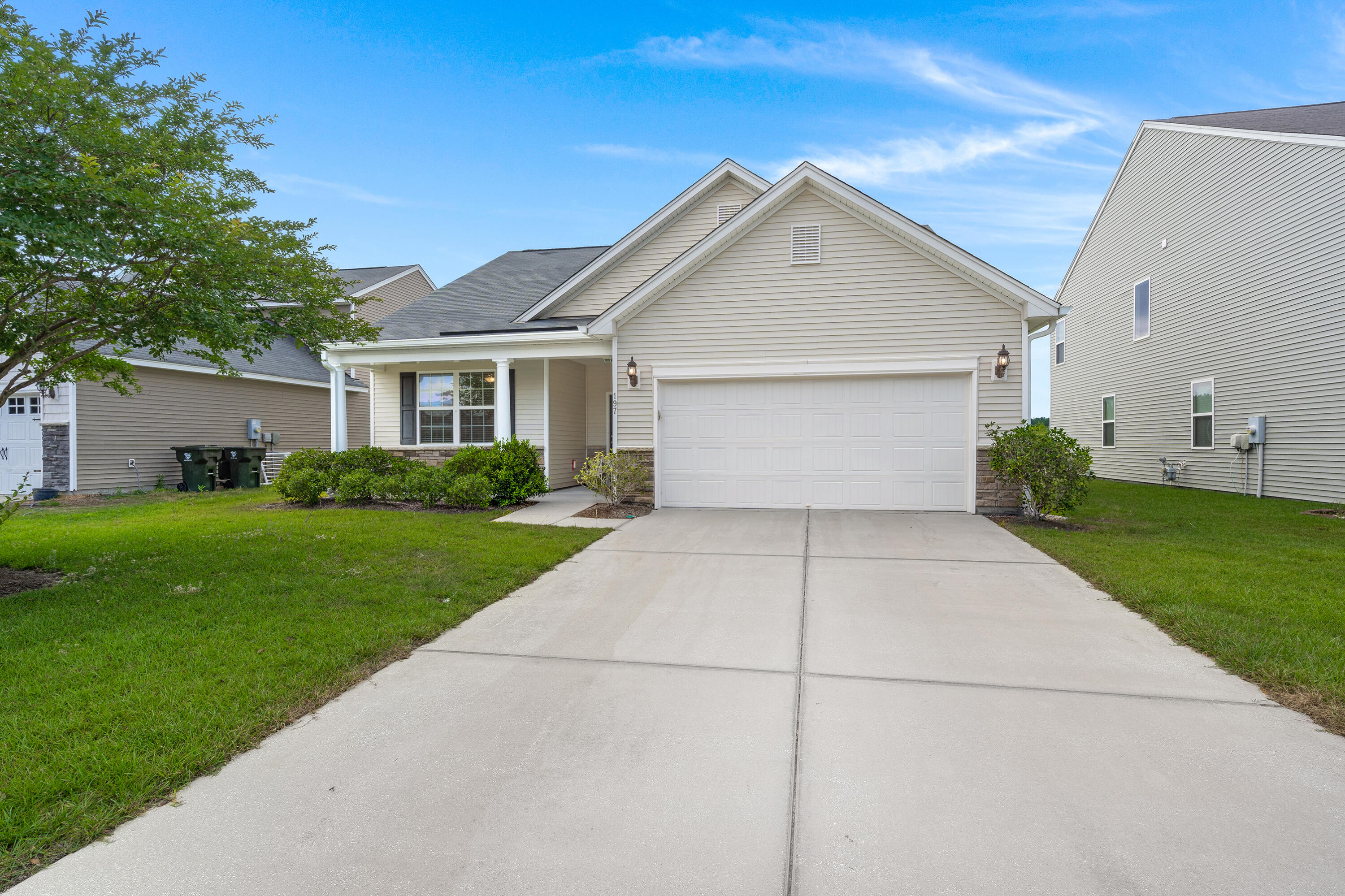 House exterior with a two-car garage, covered porch, and wide concrete driveway.