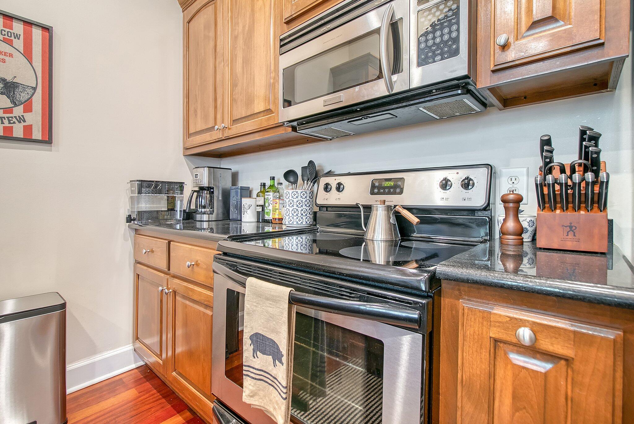 Kitchen with wood cabinets, granite counters, and stainless-steel range and microwave.