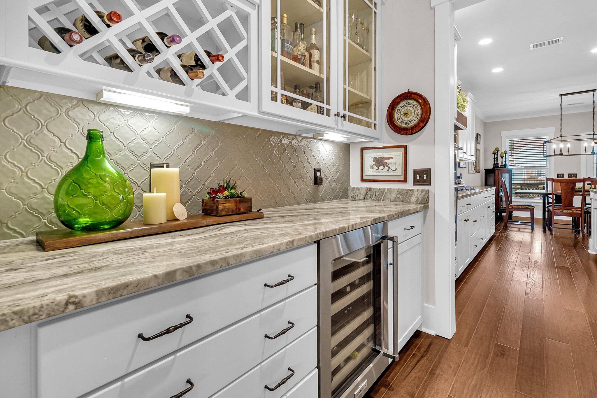 Kitchen with a long marble counter, wine storage, and an adjoining dining area.