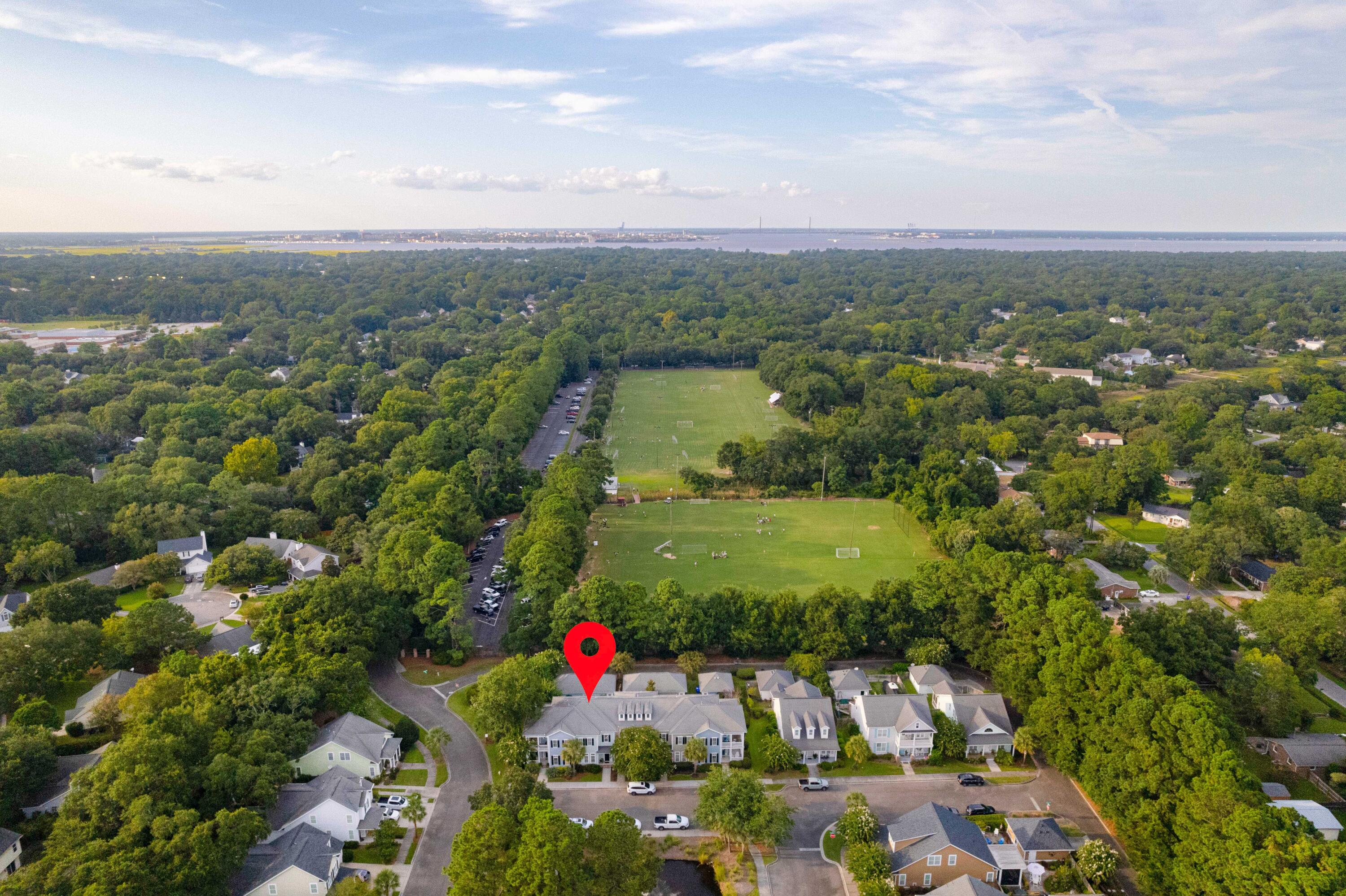 Aerial view of a home marked by a red pin near wooded soccer fields.