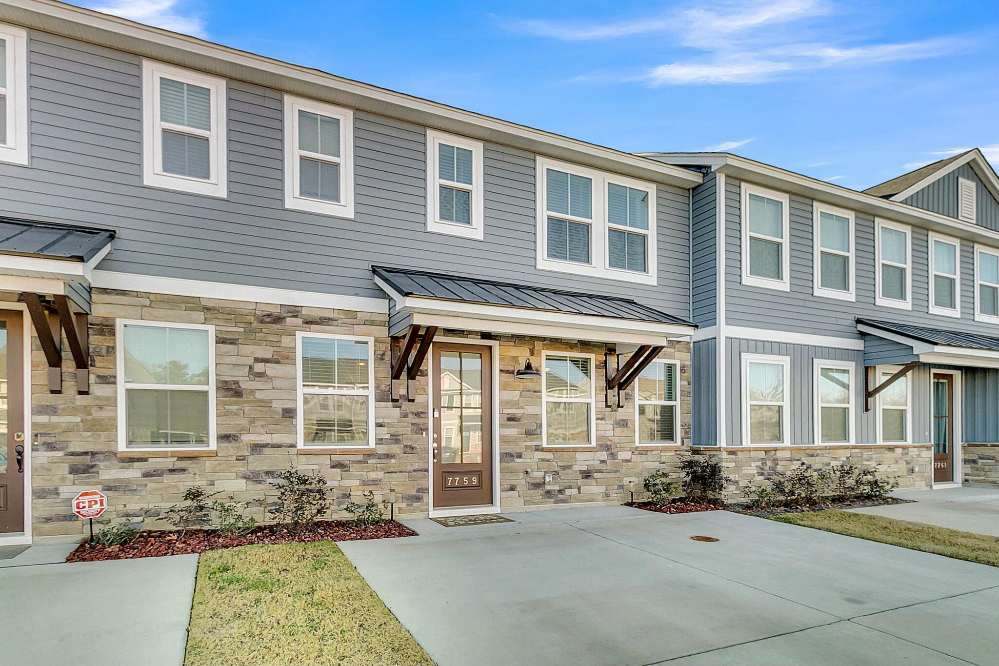 Townhouse exterior with gray siding, stone veneer, black metal awning, and front door numbered 7759.