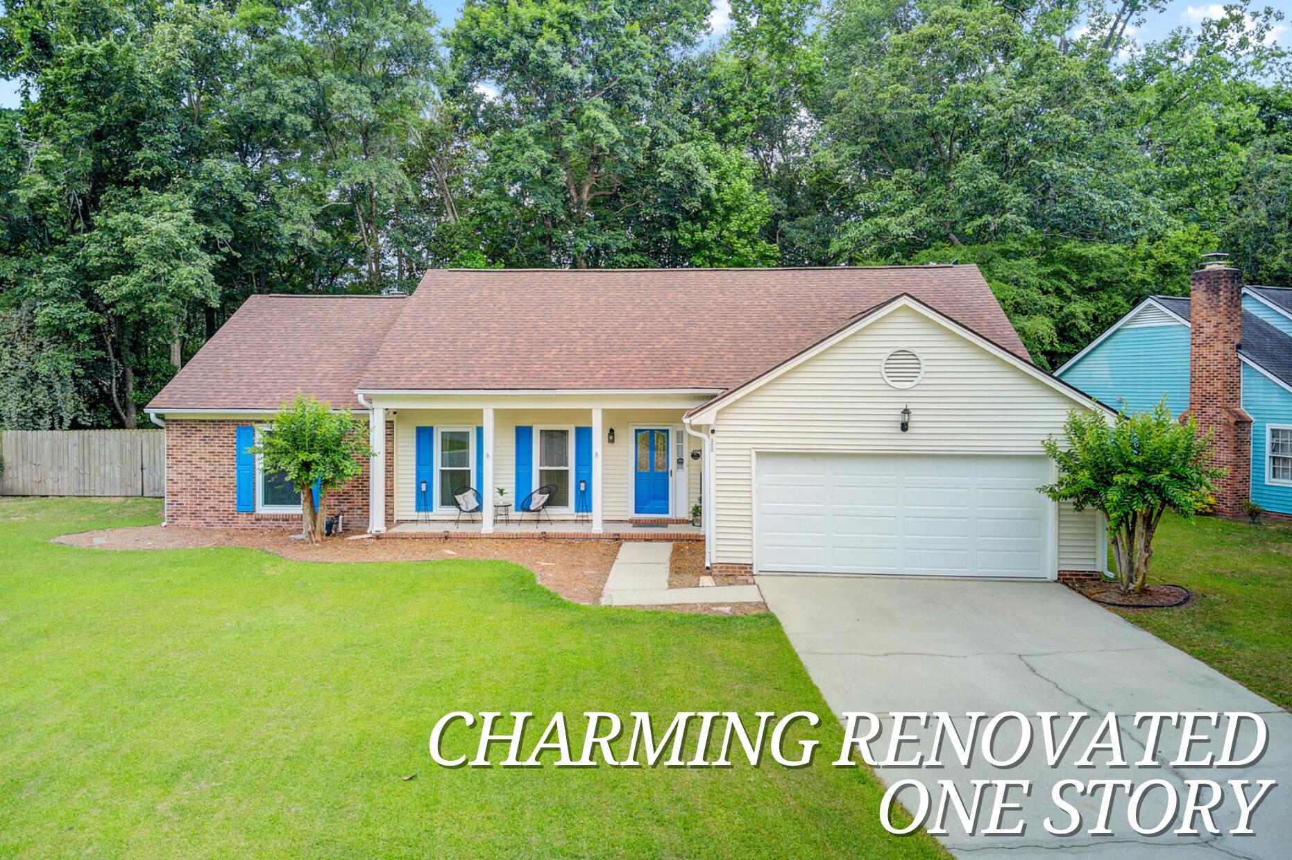 Single-story home with blue shutters, a covered porch, brick accents, and an attached two-car garage.