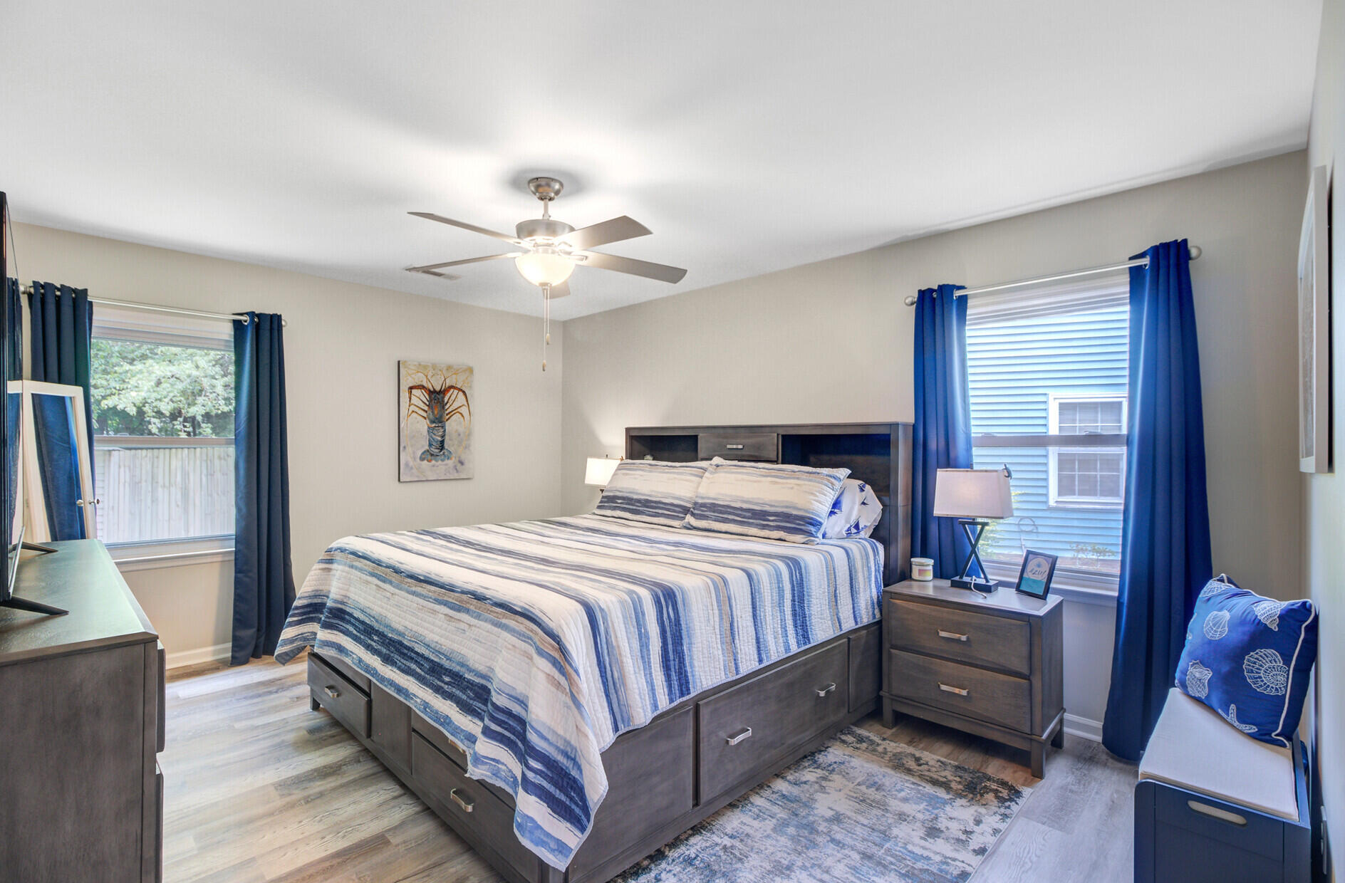 Bedroom with a dark wood bed, blue-and-white striped bedding, and blue curtains.