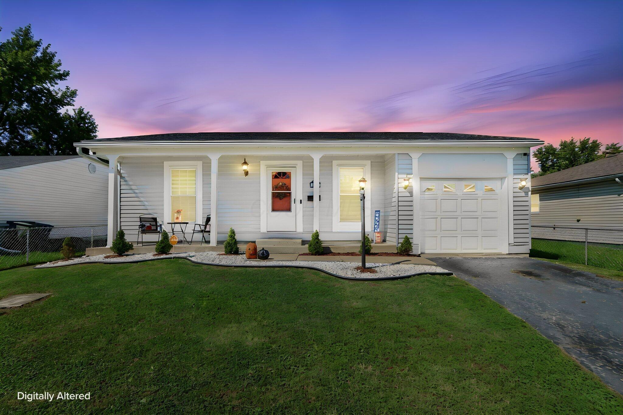 White single-story house with attached garage and covered porch at dusk.
