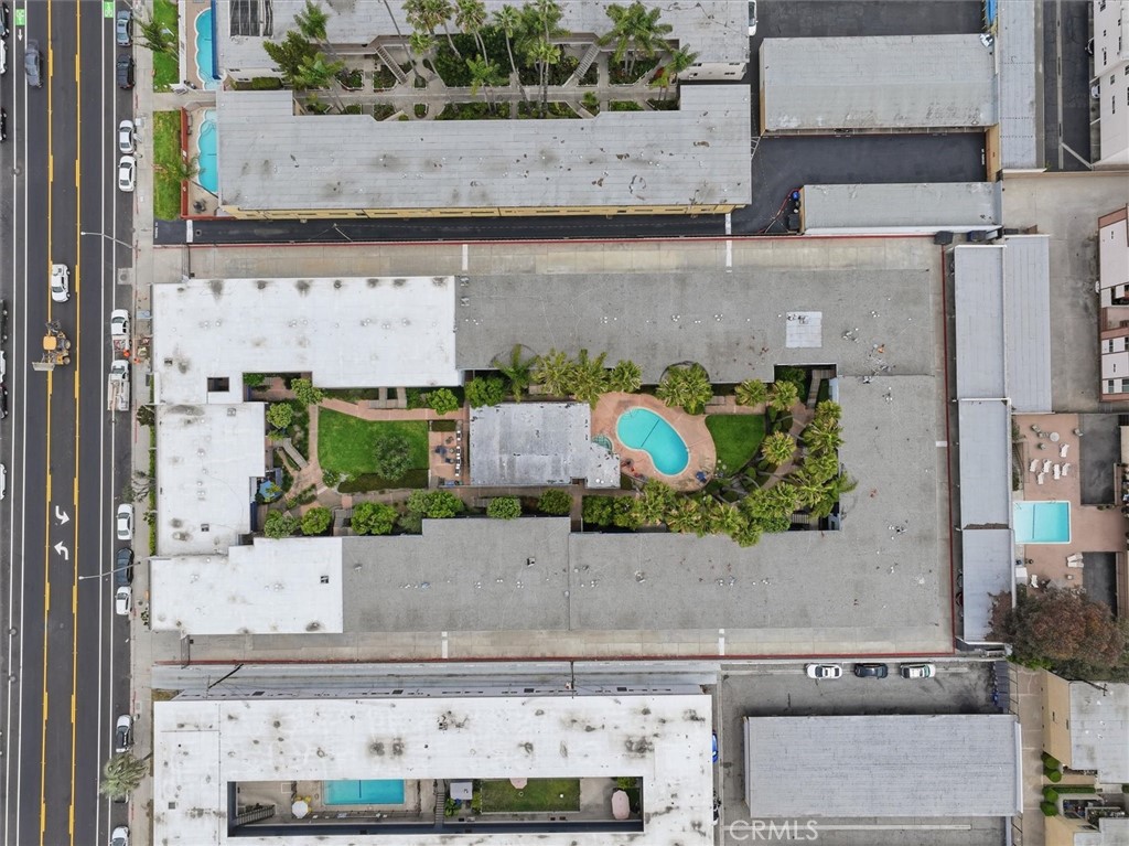 Aerial view of an apartment complex with a landscaped courtyard and swimming pool.
