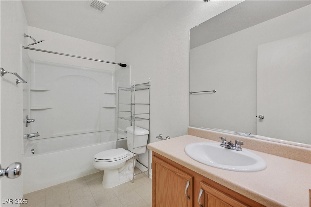 Bathroom with a tub and shower, toilet, and wood-front vanity with an oval sink.