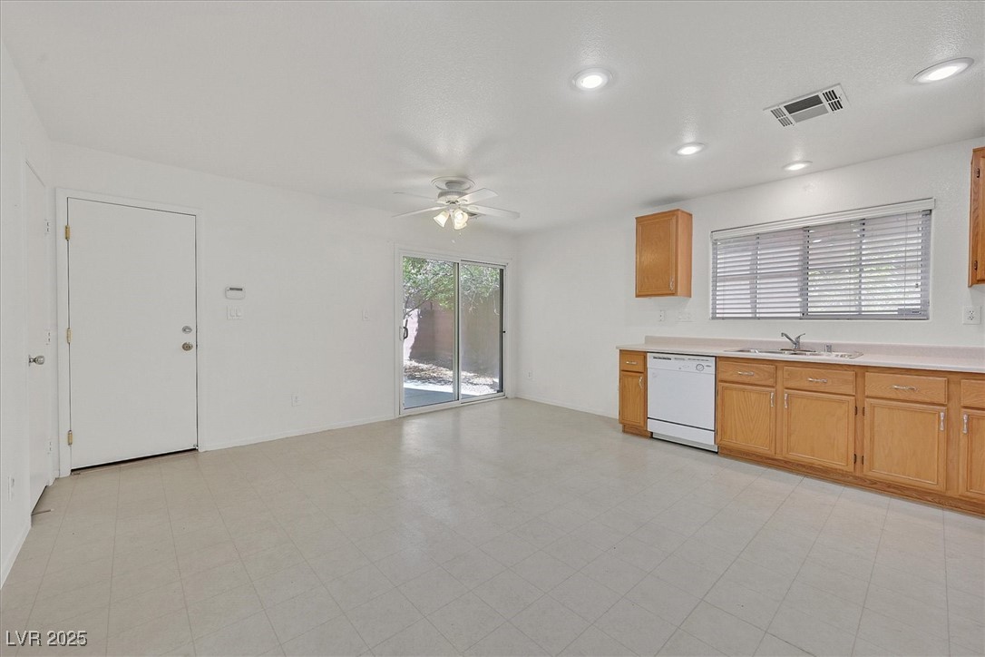 Vacant kitchen with wood cabinets, tile flooring, and a sliding glass door to the yard.