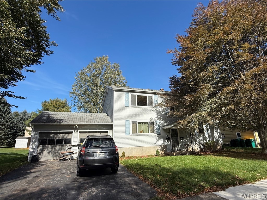 Two-story house with an attached garage, driveway, parked SUV, and mature trees.