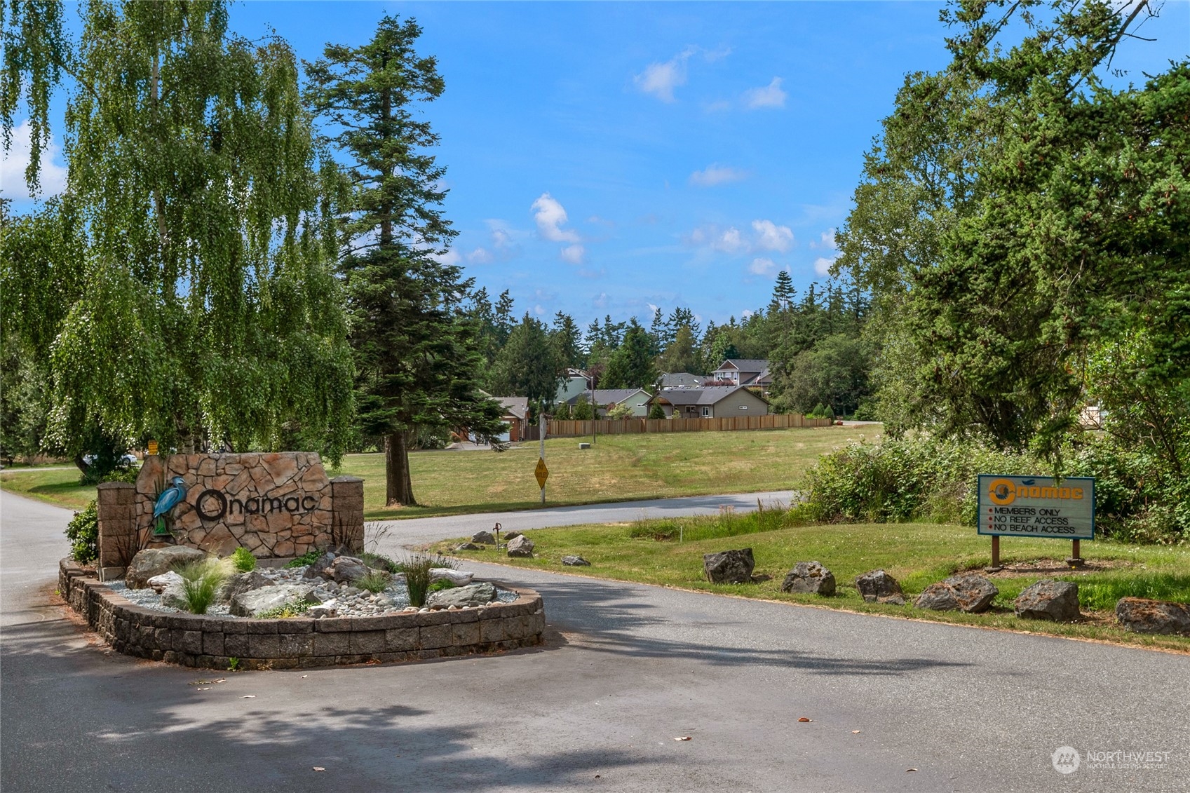 Onamac community entrance with a stone monument sign and a members-only access sign.