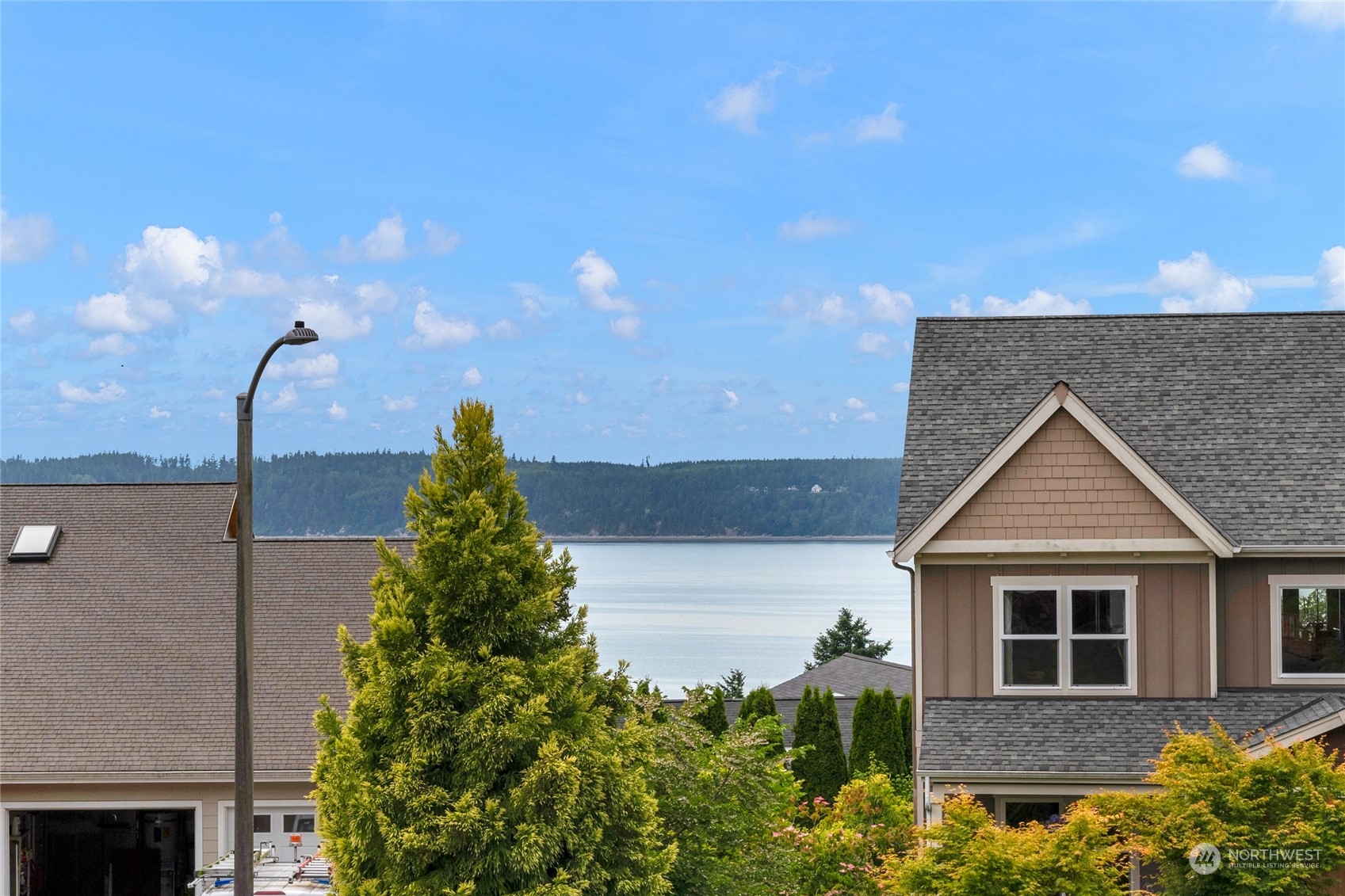 Homes and landscaped yards overlook calm water and a forested shoreline.