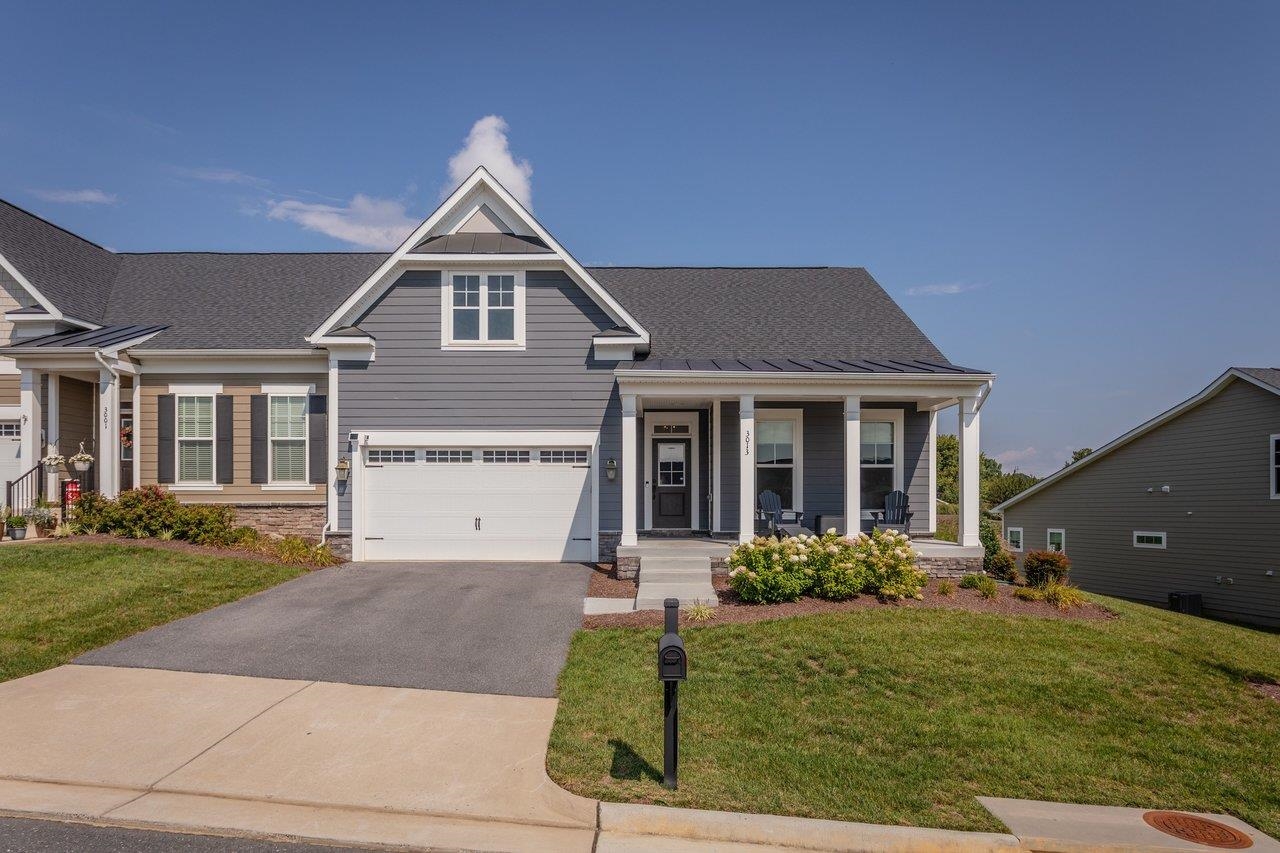 Gray two-story home with a prominent front gable, attached garage, and covered porch.