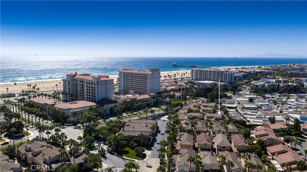 Aerial view of coastal homes beside a sandy beach and Pacific Ocean, with a location marker.