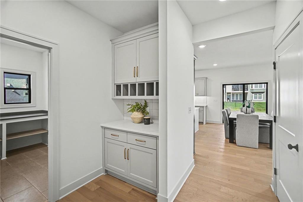 Built-in white serving station with open cubbies between a work nook and dining area.
