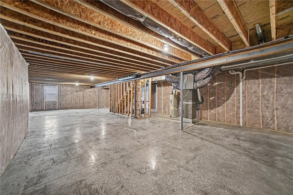 Unfinished basement with exposed framing, a concrete floor, and visible HVAC equipment.