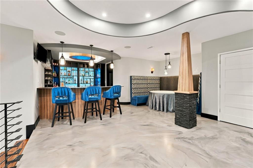 Home entertainment room with a built-in bar, blue stools, and booth seating.