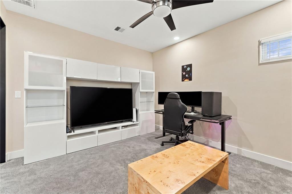 Home office and media room with white built-in TV cabinetry and a computer desk.