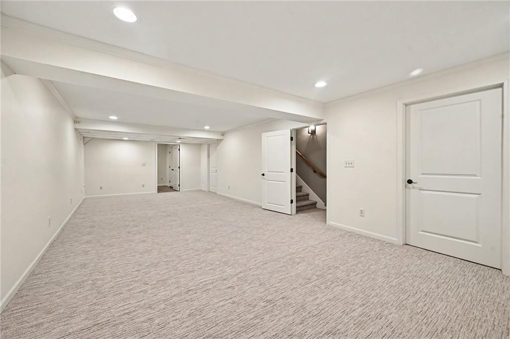 Finished basement rec room with light carpeting and an open doorway to the stairs.