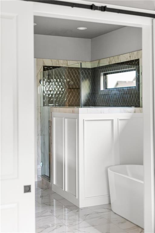 Bathroom with a glass-enclosed shower, dark geometric tile, and a freestanding tub.