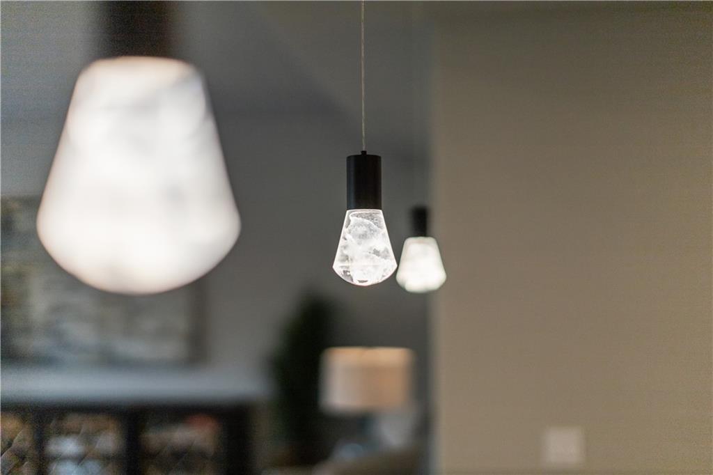 Three pendant lights, with the center bulb in focus against a softly blurred interior.