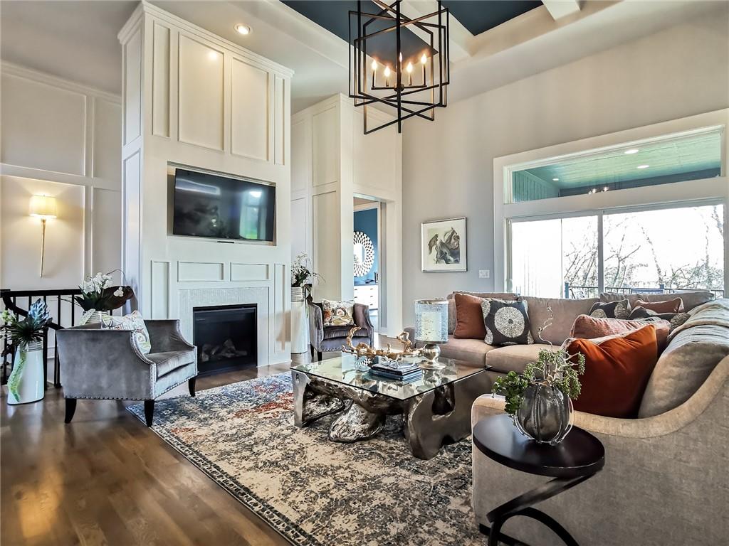 Living room with a fireplace, built-in television cabinetry, and large windows.