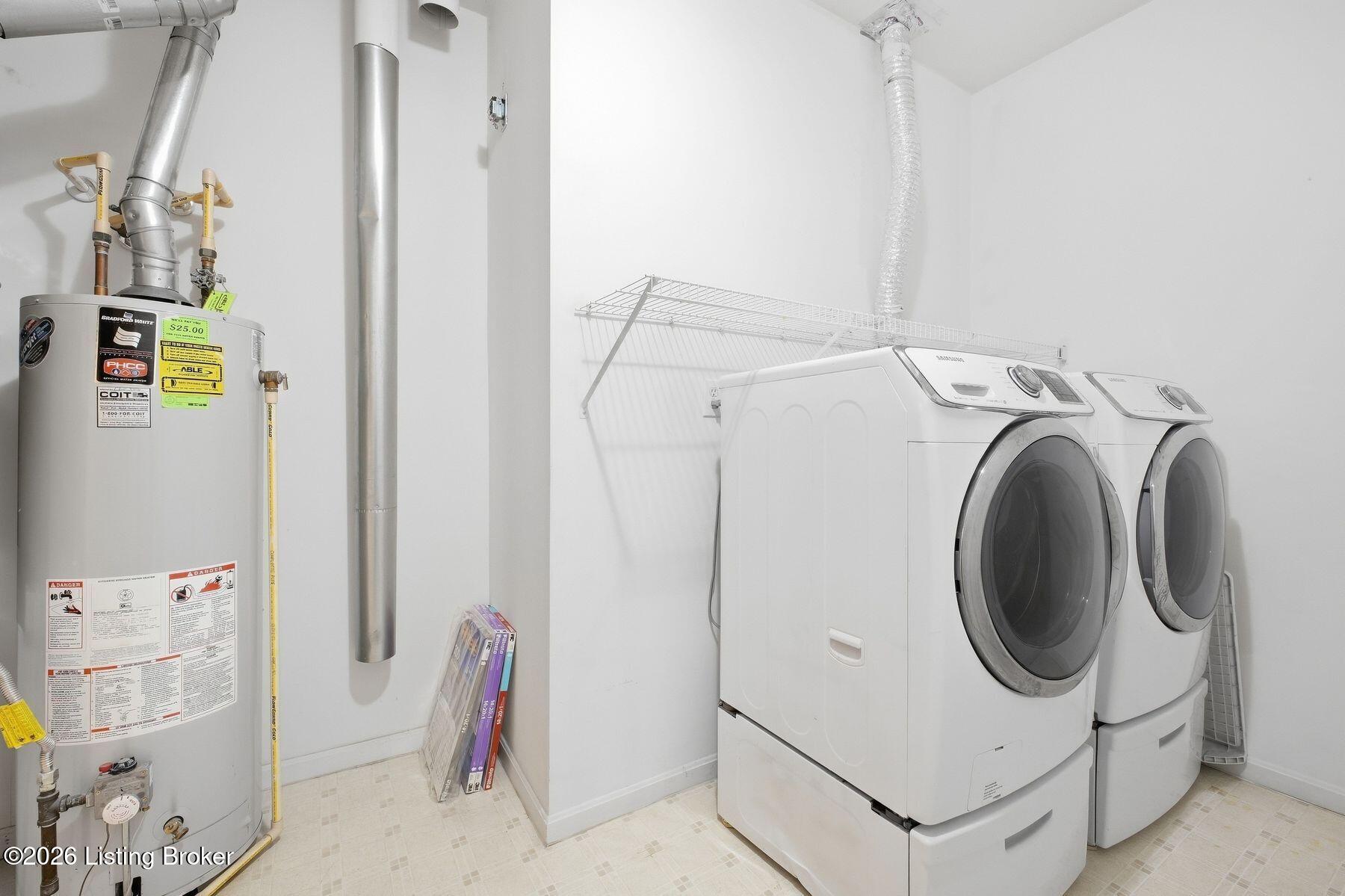 Laundry and utility room with front-loading washer and dryer, wire shelf, and water heater.