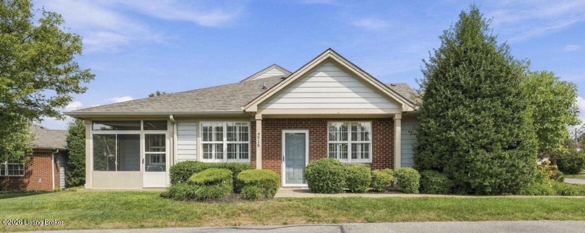 Single-story brick-and-siding home with a covered entry, enclosed sunroom, and landscaped front yard.