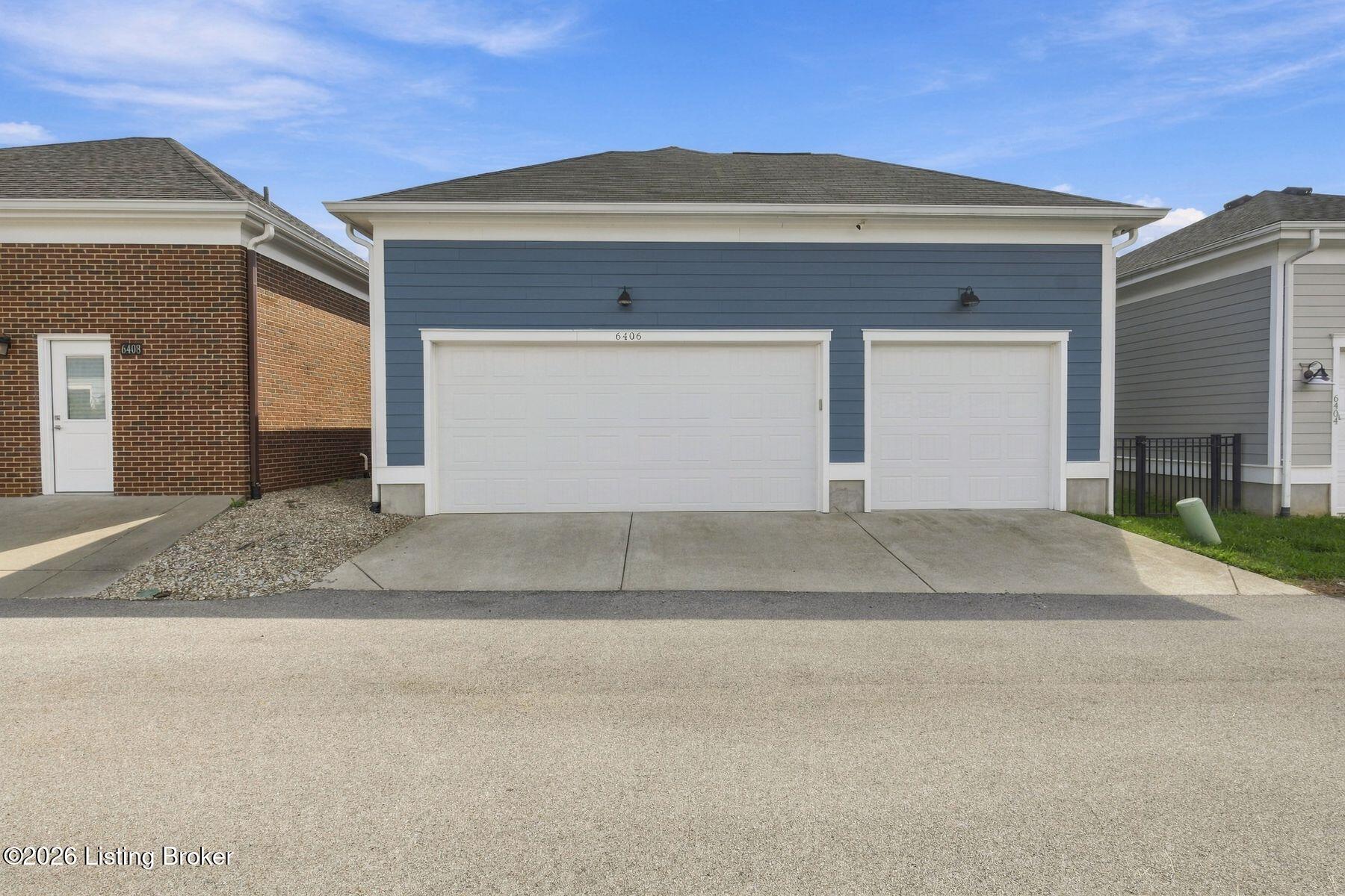 Blue-sided home with white trim, double and single garage doors, and a paved driveway.