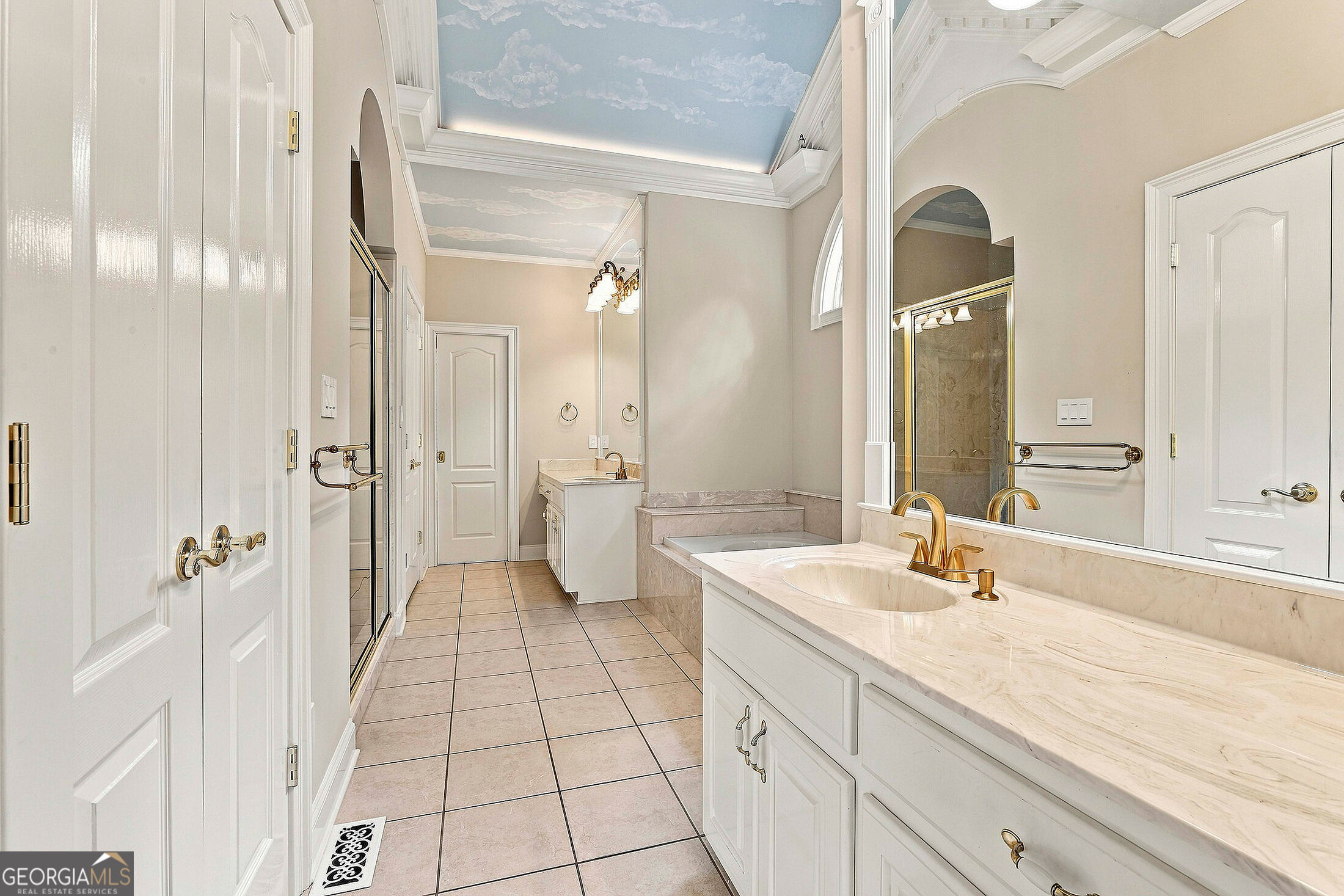 Bathroom with white vanities, raised soaking tub, glass shower, and a sky-painted ceiling.