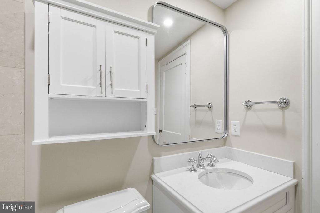 Bathroom with a white vanity, oval sink, mirrored medicine cabinet, and chrome fixtures.
