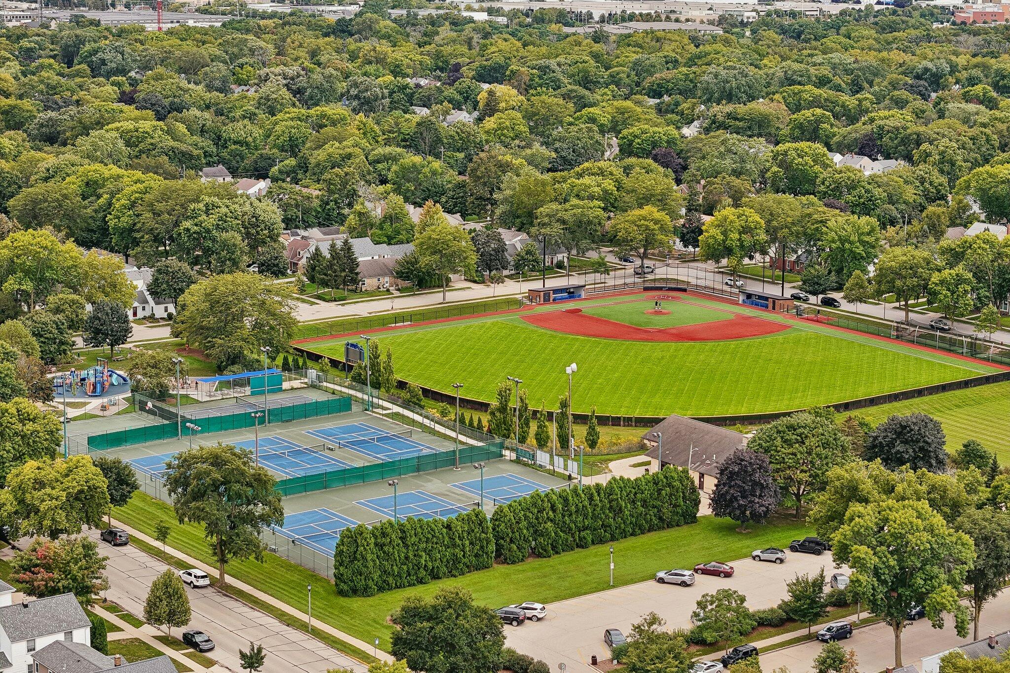 Aerial view of neighborhood recreation grounds with baseball field, tennis courts, and playground