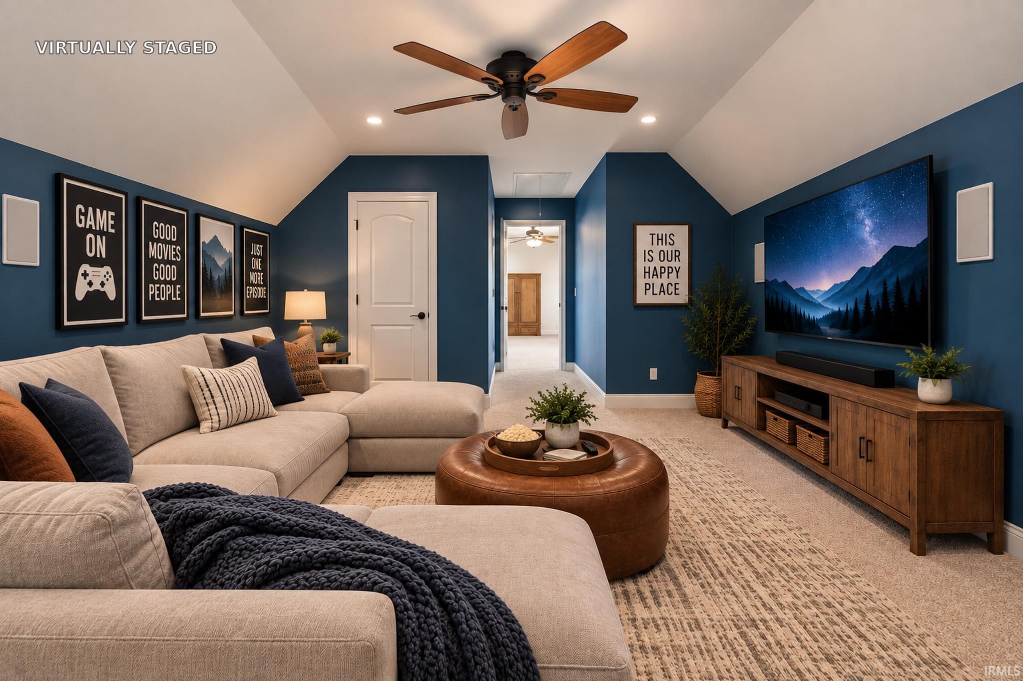 Virtually staged family room with a beige sectional, blue walls, and a large television.